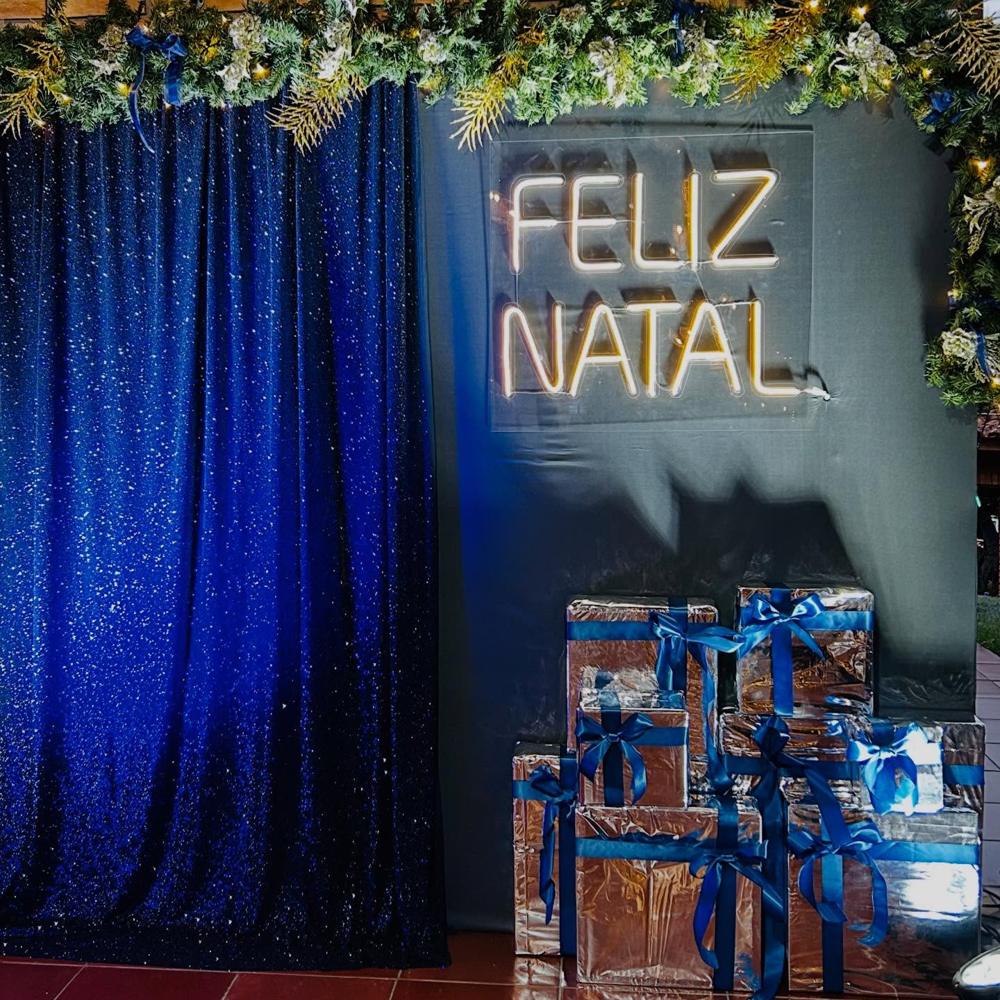 Cenário de Natal com painel azul e letreiro Feliz Natal